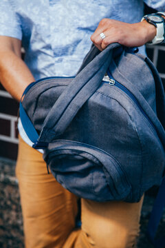 Closeup of man's arms delving in backpack