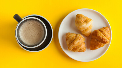 Banner coffee mug cappuccino and croissant on a yellow background. Minimalism. Sweet food, delicious Breakfast.
