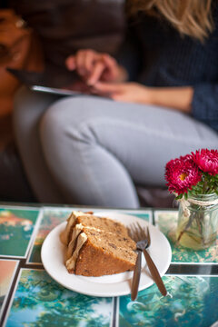 woman holding a tablet computer in a cafe with coffee and cake