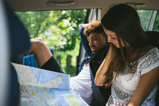 Friends watching a map sitting in the car
