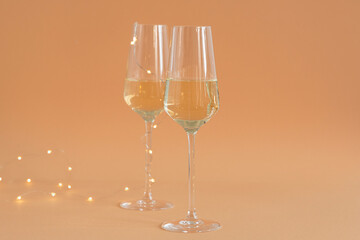 Glasses are filled with champagne  against the background of bokeh lights.
