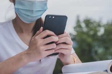 Asian women in face mask  holding phone online E-learning