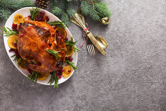 Christmas table with baked chicken is festively decorated with candles.top view