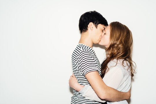 Couple kissing in front of a white background