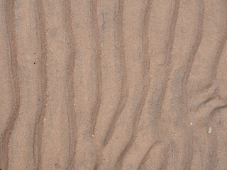 Fototapeta na wymiar Rippled sea sand beach surface texture, background, pattern