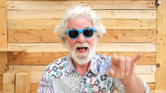 Handsome senior aged alternative diverse caucasian mature man in front of the camera in funny and nice portrait - cheerful retired people have fun and enjoy life