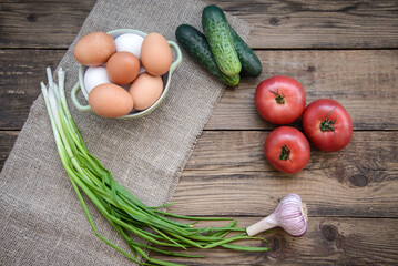 Vegetables and eggs on a wooden background