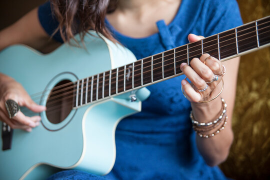 girl strumming blue guitar