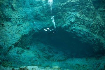 Diver's immersion in a natural funnel with clear water. The water is only 6 degrees, the composition is hydrogen sulfide. Very beautiful shots