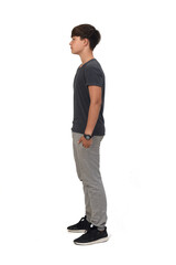 Fototapeta premium full portrait of a teenage boy dressed in sportswear on white background, side view