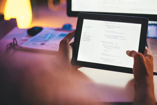 Programmer Looking at a Computer Code on a Tablet