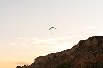 Paraglider in the blue sky. The sportsman flying on a paraglider.
