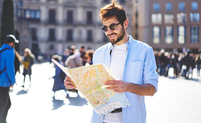 Cheerful man with map on street