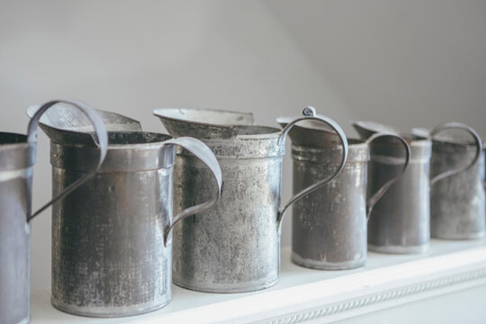 Row of Antique Tin Jugs and Pitchers as Home Decoration