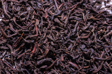 Dried black tea leaves, textured background