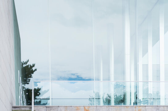 The reflection of blue sky and white clouds on glass of a building.