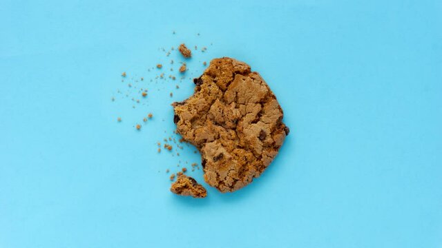 Creative concept flatlay stop motion media video movie footage chocolate cookie bite on blue background.
