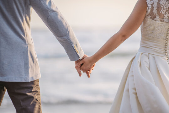 Couple Holding Hands In Front of Sea