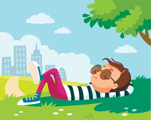 Portrait of a boy lying/resting/lies on green lawn in shade of tree in park, city outskirts. Summer.