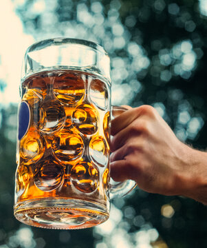 Man holding a full stein of beer at an Oktoberfest party