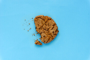 Creative concept flatlay food diet photo of chocolate cookie bite on blue background..