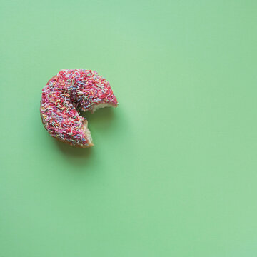 donut with a bite on a green background