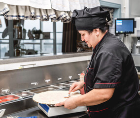 baker making pizza at the pizzeria kitchen