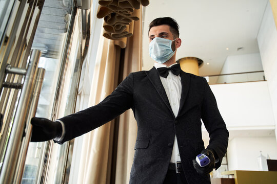 Young Hotel Receptionist Working In Medical Mask And Rubber Gloves