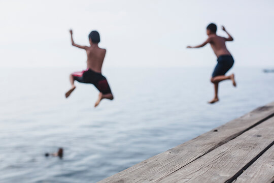 Boys jumping from the jetty