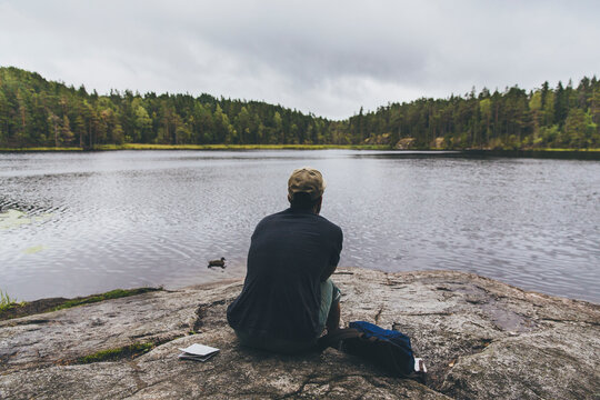 Man resting on rocks by a lake