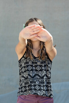 Teen girl holding her hands up - she doesn't want her photo taken