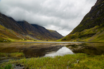 Naklejka premium Rio reflejando nubes del cielo en Valle de Glencoe