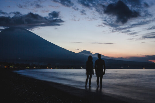 Couple walking on the beach at night.
