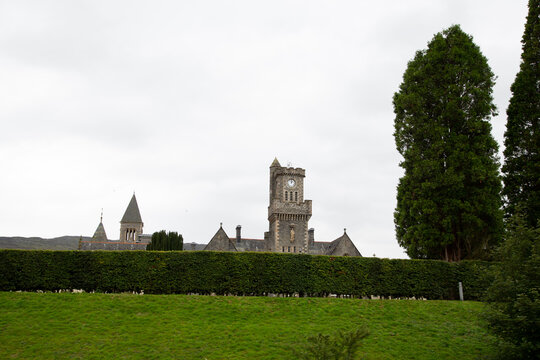 Vista de monasterio con linea de setos gran &aacute;rbol y colina de prado