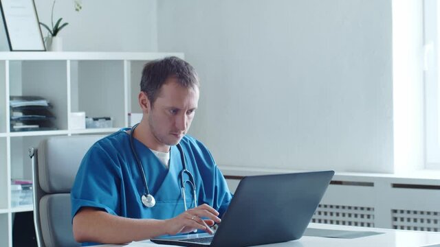 Professional medical doctor working in hospital office using computer technology.