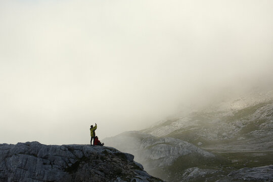 People taking pictures and enjoying the view of a foggy mountain landscape