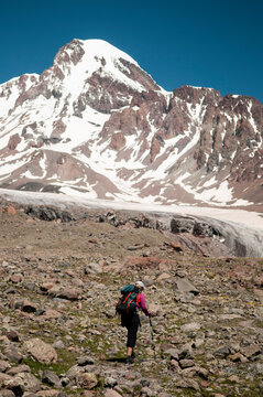 Woman trekker walking towards Mount Kazbek, Caucasus Mountains, Georgia.