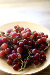 Wooden bowl full of red grapes. Selective focus.