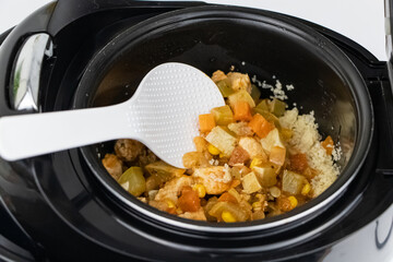 Macro video of a multicooker. The man opens the pan and mixes the dish. The concept of cooking automation and ease in the kitchen.