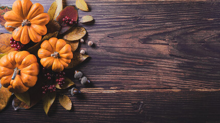 Autumn background decoration from dry leaves and pumpkin on dark wooden background. Flat lay, top view with copy space for Autumn, fall, Thanksgiving concept.