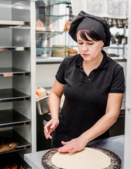 baker making pizza at the pizzeria kitchen