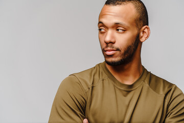 Obraz premium Joyful friendly african-american young man in green t-shirt over light grey background with copy space
