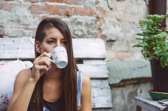 Young brunette girl drinking coffe