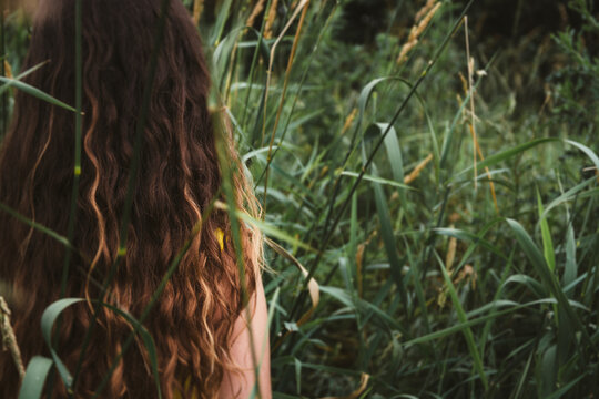 Young Girl Standing in Tall Grass Outside