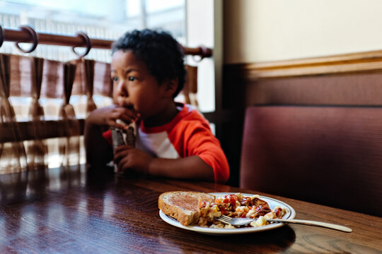 toddler boy refusing breakfast in diner