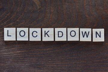 written "LOCKDOWN" with light wood letters on dark wood