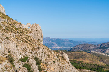 Fototapeta na wymiar Forata rock hole with the city of Cocentaina in the background, Aitana mountain.