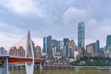 Obraz premium Panorama view of the Qiansimen bridge and skyline in Chongqing, China, on a cloudy day.