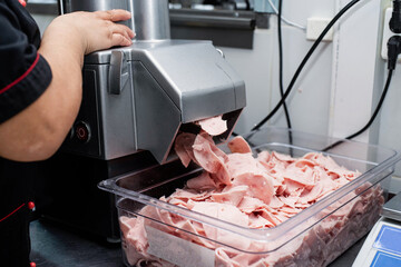 woman is working on meat grinder machine, forcemeat process for making sausages