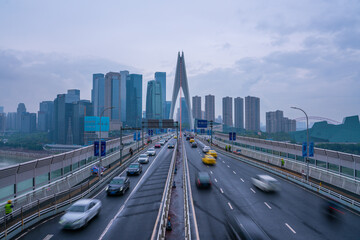 Fototapeta premium The traffic on qiansimen bridge, with the financial district in Chongqing, China, on a cloudy day.